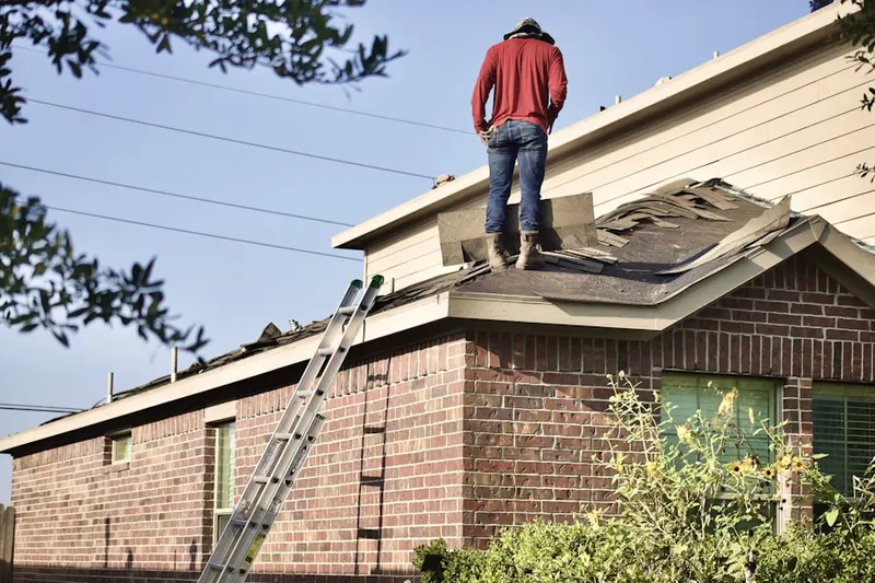 Professional roofer working on a residential roof in Country Roads